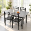 Grey stone-look dining table and four black scroll-back chairs beside a sunlit window Grey stone-look dining table and four black scroll-back chairs beside a sunlit window